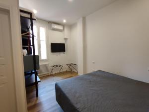 une chambre avec un lit et une télévision à écran plat dans l'établissement Residenza Maggiore 10 - Affittacamere - Guest House, à Bologne