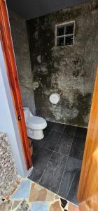 a bathroom with a toilet and a window at Casa Jabalí Ecocchic in Tulum