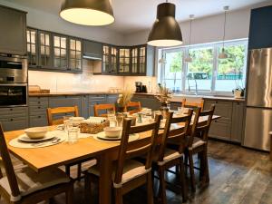 a large kitchen with a wooden table and chairs at SB Apartment with Sauna in Kołobrzeg