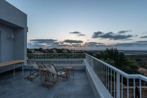 a balcony with chairs and a table and a sunset at Sea view in Kabri