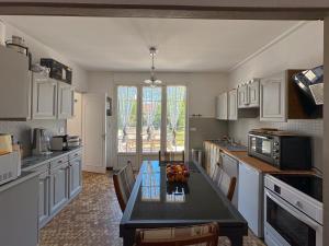 een keuken met een tafel en stoelen erin bij Villa familiale proche Océan in Soulac-sur-Mer