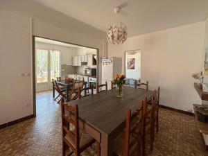 een eetkamer en keuken met een tafel en stoelen bij Villa familiale proche Océan in Soulac-sur-Mer