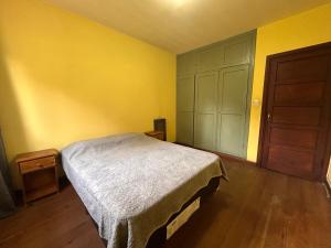 una camera da letto con un letto e un pavimento in legno di Casa Azucena a El Bolsón