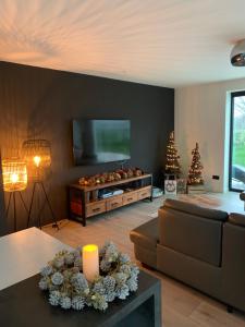 a living room with a couch and a tv and a christmas tree at Villa Steedje in Jabbeke