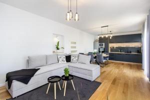a living room with a white couch and a kitchen at Trogirski san in Trogir