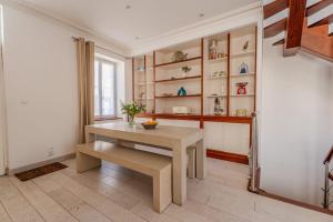 ein Esszimmer mit einem Tisch und einem Regal in der Unterkunft Maison de vacances avec Garage privé in Les Sables-dʼOlonne