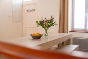 Eine Vase mit Blumen und eine Schale mit Obst auf einem Tisch. in der Unterkunft Maison de vacances avec Garage privé in Les Sables-dʼOlonne