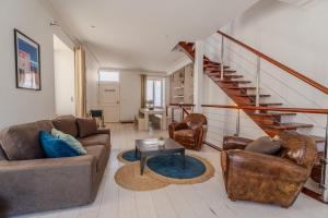 ein Wohnzimmer mit 2 Sofas und einer Treppe in der Unterkunft Maison de vacances avec Garage privé in Les Sables-dʼOlonne