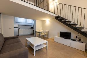 a living room with a couch and a table and a staircase at Broglio Studios in Milan