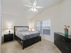 Un dormitorio con una cama y un ventilador de techo. en 1068 Z4B VILLAGE OF PINE RIDGE by REMAX Premier, en The Villages