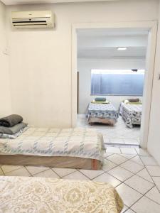 a bedroom with three beds and a window at Casa Nossa Senhora de Nazaré 2 in Belém