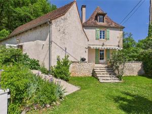 an old house with a green door and a yard at Villa 'Le Roc' pour 10, jardin et piscine in Thonac