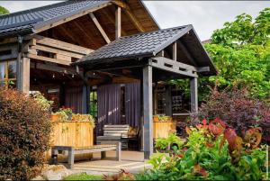 a wooden pavilion with a bench in a garden at Hotel Bannyi Dvir in Uzyn