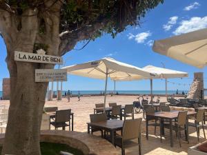 a cafe with tables and umbrellas on the beach at La Mata relax in La Mata