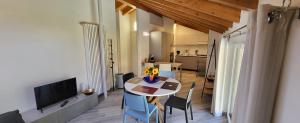 a living room with a table and chairs and a television at Casa Camoscio Piano 2 in Cannobio