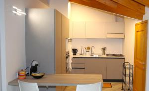 a kitchen with a wooden table and a kitchen with white cabinets at Casa Camoscio Piano 2 in Cannobio