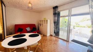 Una sala de estar con una mesa y sillas blancas. en Studio Cocody 8 LUMIO, en Lumio