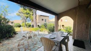 Una mesa y sillas en un patio. en Studio Cocody 8 LUMIO, en Lumio
