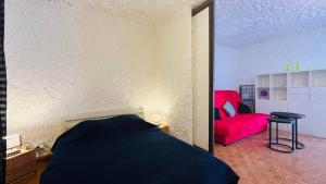 Un dormitorio con una cama y un sofá rojo. en Studio Cocody 8 LUMIO, en Lumio