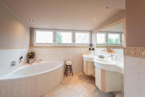 a bathroom with two sinks and two bath tubs at Landhaus Christl am See in Bad Wiessee