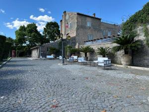 a cobblestone street with benches in front of a building at Villa Grant Relais in La Capocotta