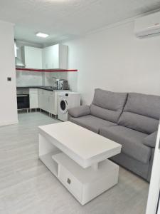 a living room with a couch and a table at Bungalow con barbacoa in Torrevieja