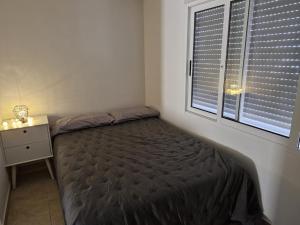 a small bedroom with a bed and a window at Bungalow con barbacoa in Torrevieja +2 photos