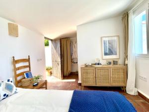 a bedroom with a bed and a wooden dresser at Bunker House in Algeciras