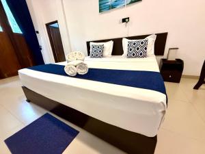 a bedroom with a large bed with towels on it at Divine Villa in Anuradhapura