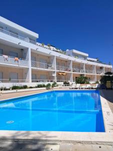 a large swimming pool in front of a large apartment building at Apartamento T3 sta luzia in Santa Luzia
