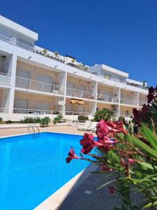 a hotel with a swimming pool in front of a building at Apartamento T3 sta luzia in Santa Luzia