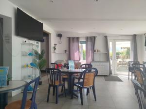 a kitchen and dining room with a table and chairs at Camping Paradis Le Grand' R in La Faute-sur-Mer
