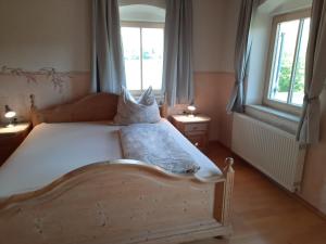a bedroom with a wooden bed with a window at Asbichlerhof in Bad Endorf