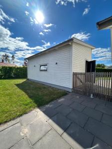 a white building with a fence in a yard at Casa Båstad in Båstad