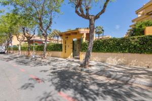 イスランティージャにあるApartamento Las Arenasの黄色い建物の前の並木道