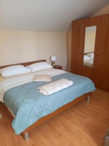 a bedroom with a large bed with blue sheets at More in Rab