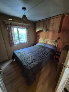a bedroom with a bed with a blue comforter and a window at Casa à leccia in Rapale