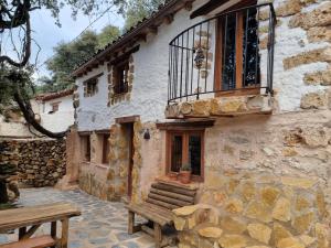 a stone building with a bench in front of it at Casa los chaparrales mirador in Los Anchos