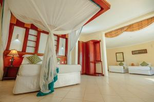 a bedroom with a bed and a living room at Kae Beach Resorts in Michamvi +23 photos