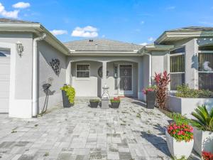 a white house with potted plants on a patio at 1257 Z2b VILLAGE OF DEL MAR by REMAX Premier in The Villages