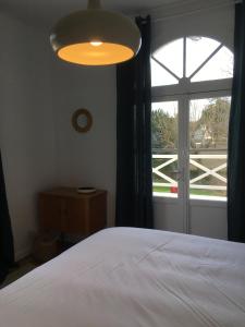 ein Schlafzimmer mit einem Bett und einem großen Fenster in der Unterkunft Petite maison de charme - Paris - Rolland Garros - Versailles - Golf - Normandie in Garches
