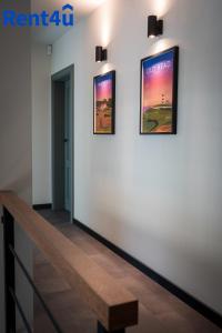 Un pasillo con dos cuadros en la pared y un banco. en Fairway House by Rent4You, en Naterki