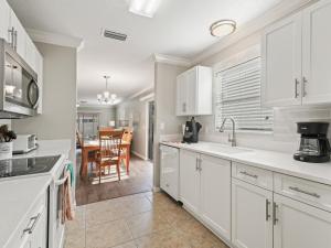 a kitchen with white cabinets and a dining room at 1315 Z2B VILLAGE OF RIO GRANDE by REMAX Premier in The Villages