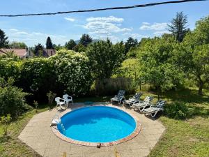 a swimming pool with chairs and a patio with a pool at Eklektikus 79 in Ábrahámhegy