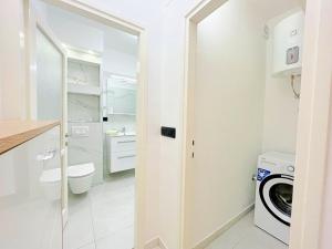 een witte badkamer met een wasmachine en droger bij Blue Dolphin in Rijeka