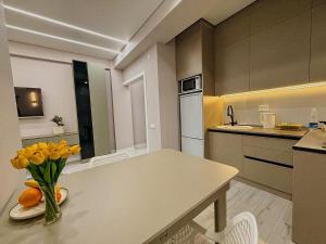 a kitchen with a table with a vase of yellow flowers at Cozy Apartment in Osh