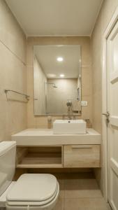 a bathroom with a sink and a toilet and a mirror at Departamento de lujo en centro de casco histórico in San Miguel de Tucumán