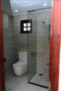 a bathroom with a toilet and a glass shower at Abbi Holidays - Private Apartment Negombo in Negombo +4 photos