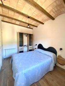 a bedroom with a large bed and a wooden ceiling at Casa la luz in La Portellada