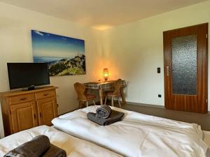 a bedroom with a bed and a table with a television at Gschwendtnerhof App10 KrausW in Aschau im Chiemgau +11 photos